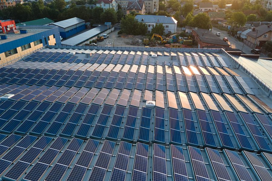 Rows of tilted solar panels on a flat commercial roof